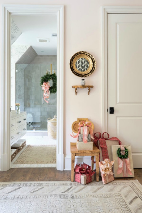 Pretty wrapped Christmas packages with pink embellishments in a bedroom within the 2018 Atlanta Holiday Showhouse.