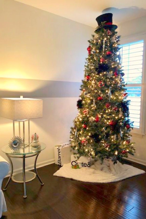 Christmas tree in a living room with white wall and wide grey stripe. Hello Lovely Studio.