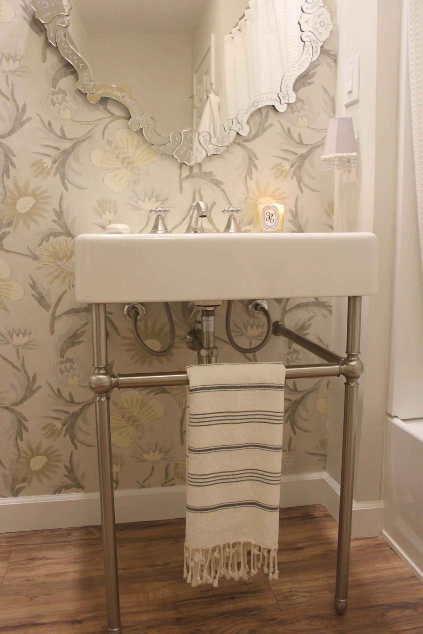 Classic console sink with fireclay farm sink and Turkish towel. Thibaut wall covering and Venetian mirror - Hello Lovely Studio.