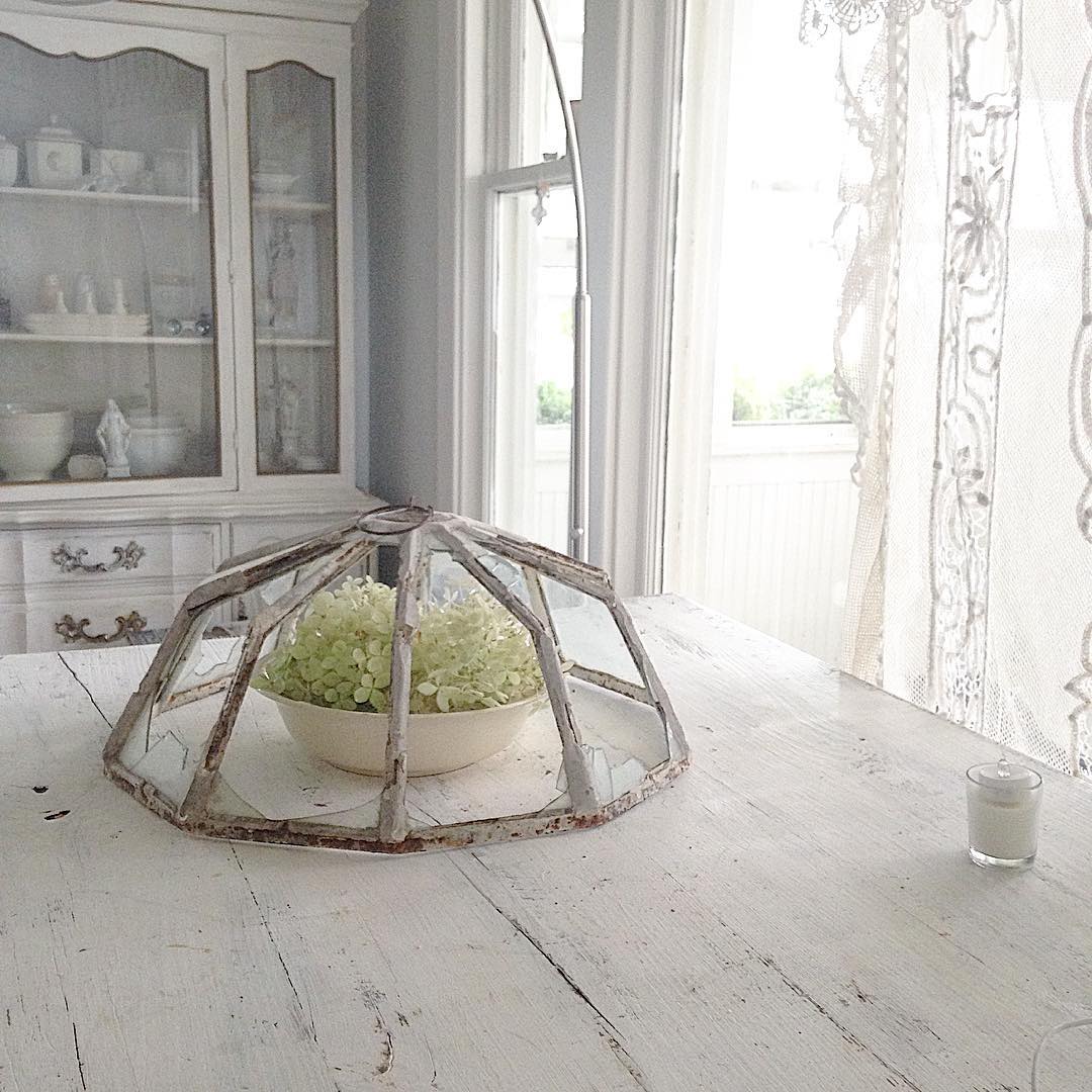 Vintage food cover used stylishly in an all white Nordic French kitchen with white farm table - My Petite Maison.
