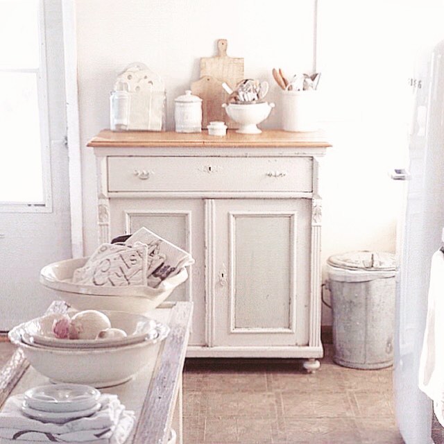 Nordic French farmhouse style in a white cottage kitchen by My Petite Maison with French ironstone, antique sideboard, and tone on tone decor.