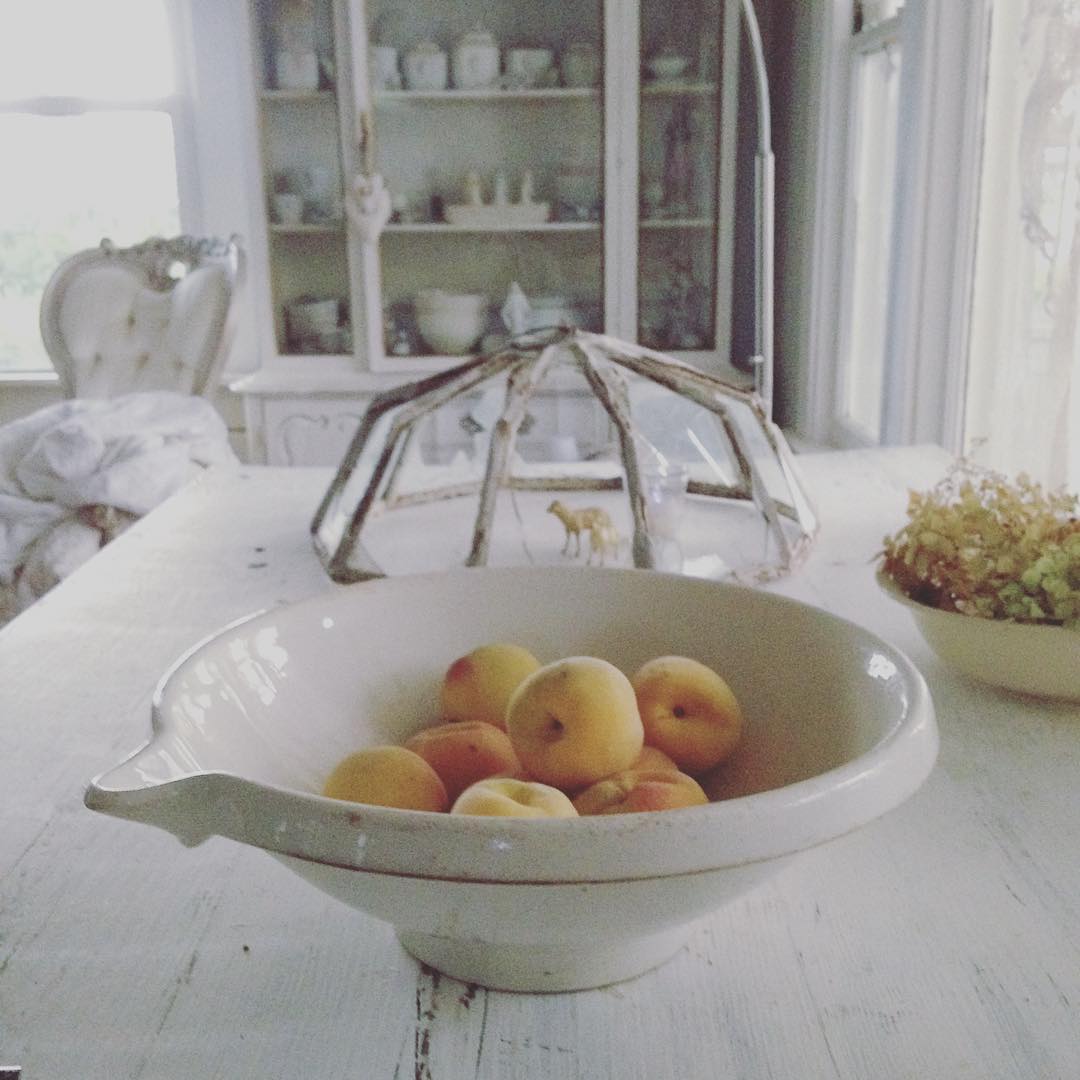 Gorgeous serene all white Nordic French kitchen with vintage kitchenware, antiques, and painted farm table - My Petite Maison.