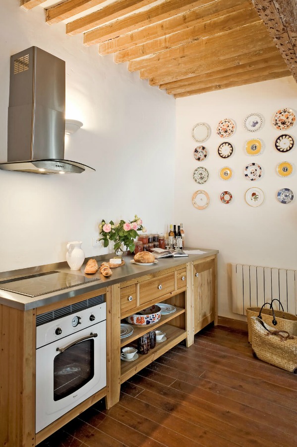 Decorative plates hung pleasingly on the wall of a French farmhouse kitchen near Provence. Haven In.