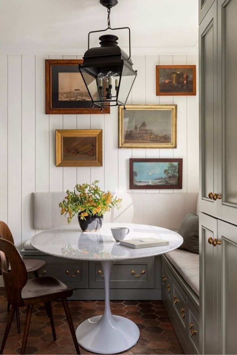 Charming breakfast nook with banquette, Saarinen table, gallery wall and lantern pendant. Heidi Callier Design. #banquette #breakfastnook #saarinentable #kitchendesign 