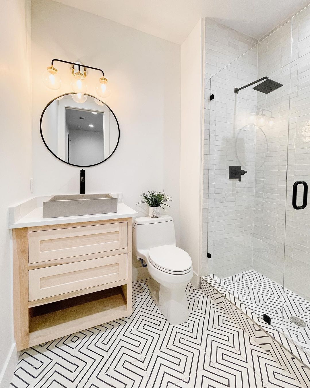 Stunning black and white cement tile flooring in bathroom (and zellige tile in shower) - @riadtile (design by @the.little.bird). #cementtile #tileflooring #bathroomtile