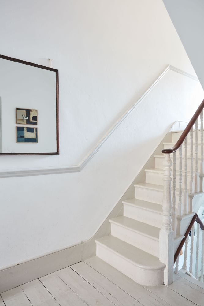 All white decor with simplicity, rustic design elements, and understated simplicity in a London Home offered by The Beach Studios. #whitedecor #housetour #simpledecor #interiordesign #vintagestyle #shabbychic