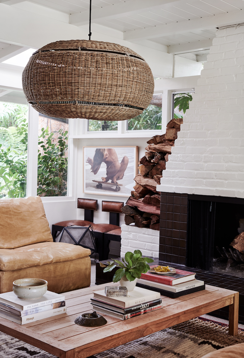 Leanne Ford's rustic modern living room with Hugh Holland skateboarder framed photograph and white painted brick fireplace. #leanneford #interiordesign #livingrooms #modernrustic #warmminimal