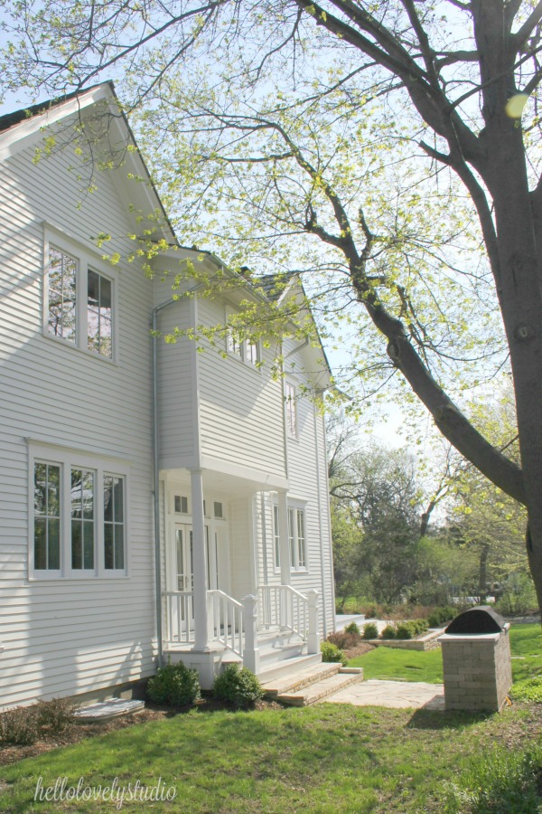 Modern farmhouse exterior - a beautiful white restored country house! Hello Lovely Studio.