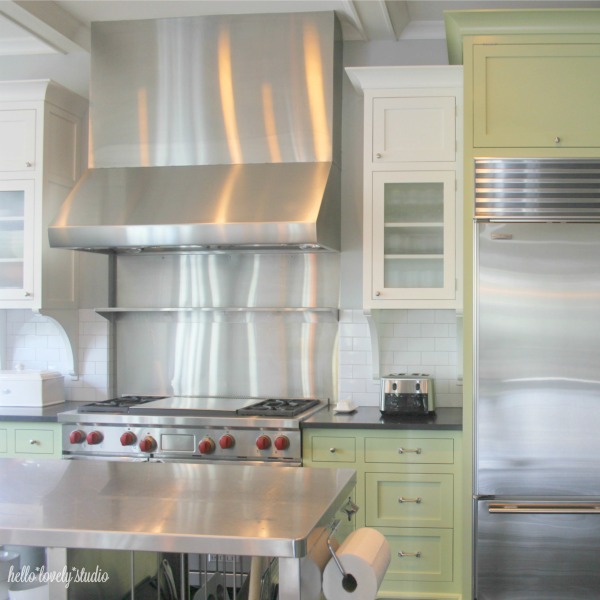 Industrial farmhouse style kitchen with stainless work island and professional range. Hello Lovely Studio.