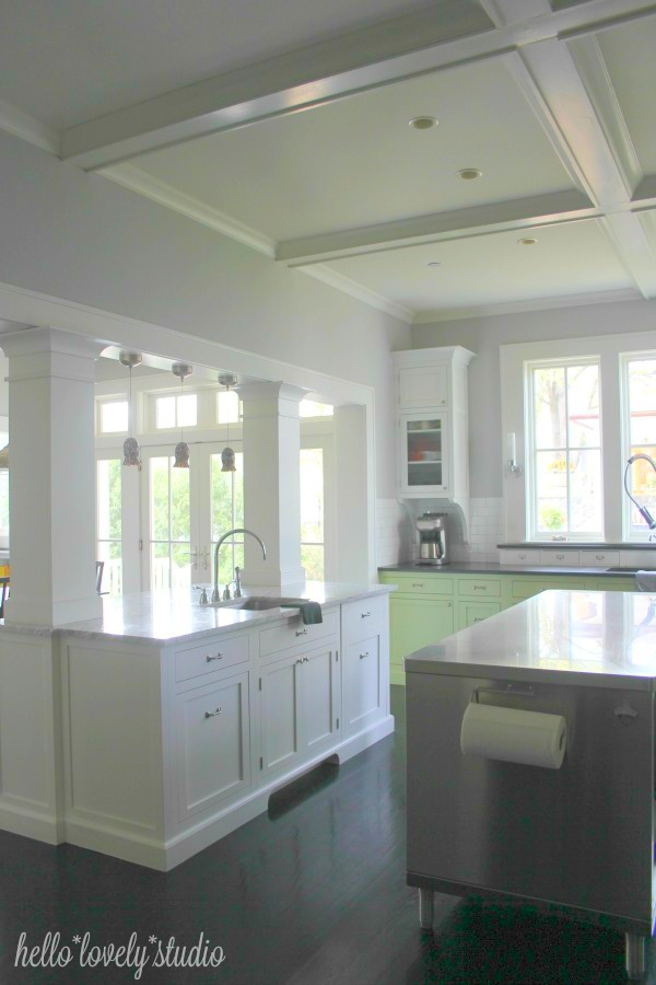 Breathtaking industrial farmhouse kitchen with stainless island, white Shaker cabinets, and pistachio painted lower cabinets. Hello Lovely Studio. #farmhousekitchen #industrial