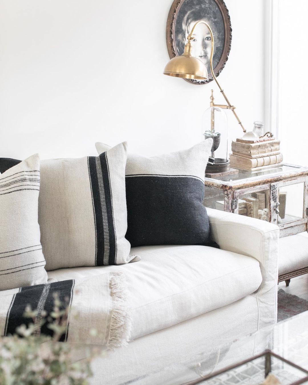 Detail of a linen Belgian style sofa with black accents on pillows in a modern rustic living room with design by @beautifulmesshome. #modernrustic #livingroom #belgianstyle