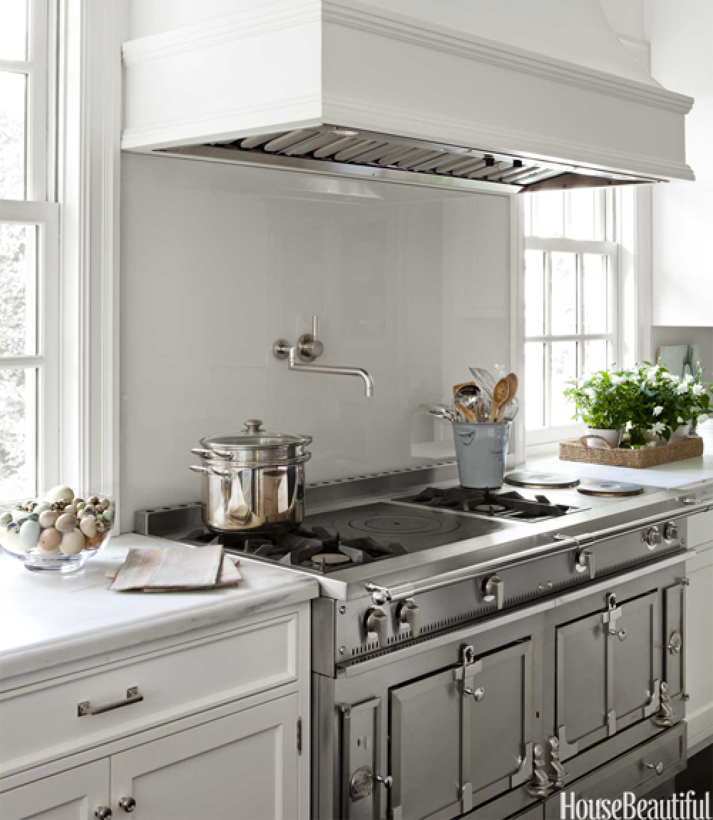 Coastal grandmother style kitchen by Samantha Lyman with ship lights over island, black floors, and classic white cabinets - House Beautiful (2012). #coastalgrandmother #coastalkitchen #somethingsgottagivekitchen