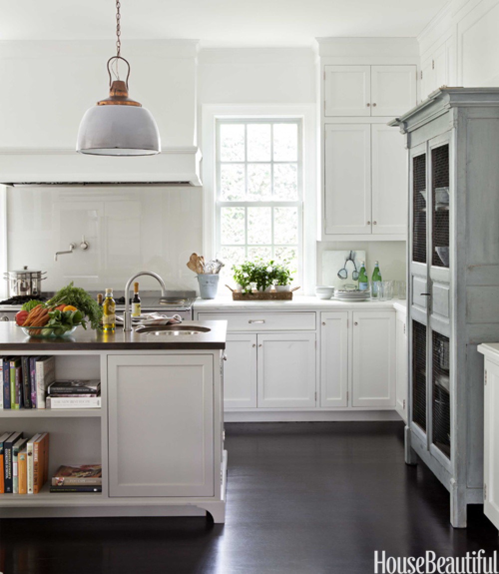 Coastal grandmother style kitchen by Samantha Lyman with ship lights over island, black floors, and classic white cabinets - House Beautiful (2012). #coastalgrandmother #coastalkitchen #somethingsgottagivekitchen