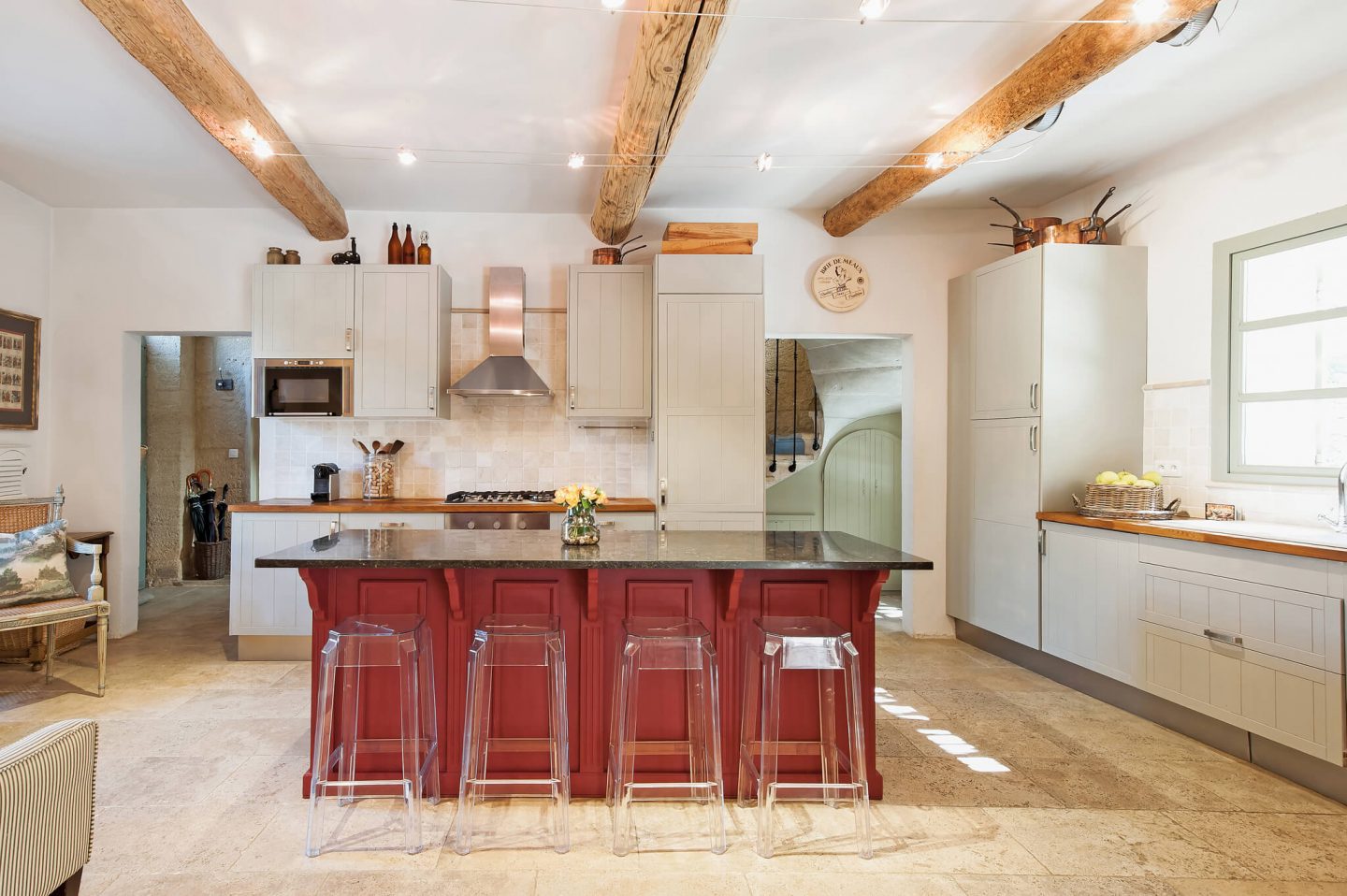 French farmhouse kitchen with modern cabinets and large center island with acrylic bar stools. Haven in.