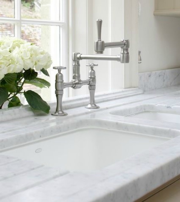 Detail of a beautiful undermount sink and marble countertop in a kitchen design by Artichoke.