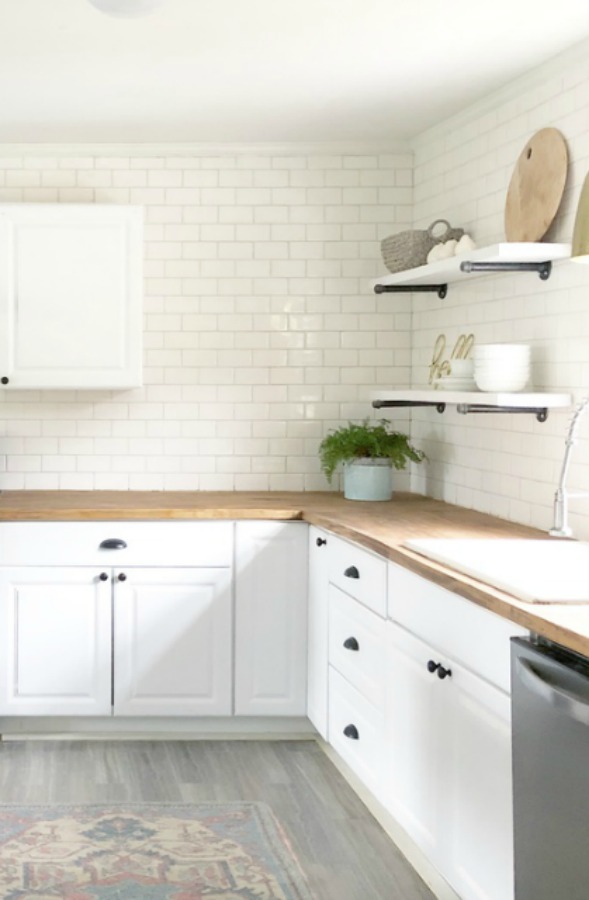 Charming white subway tile on backsplash in modern farmhouse kitchen with butcher block counters.