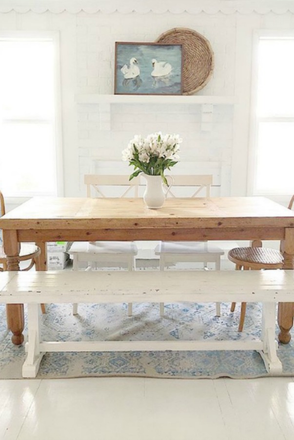 Rustic modern country dining room with wood table and white chairs.