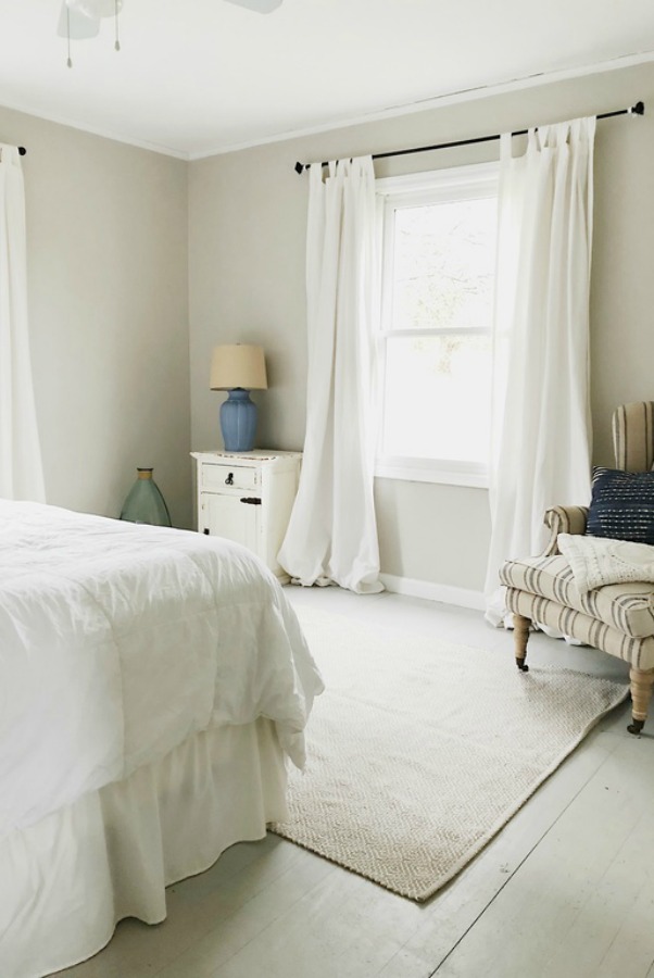 Neutral colors in bedroom with grainsack stripe accent chair.