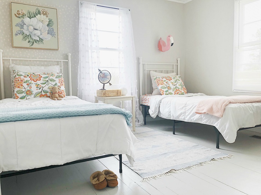 Charming kids room with cottage style white beds and soft color palette.