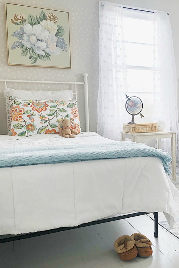 Lovely vintage style shabby chic cottage bedroom with white metal bed.