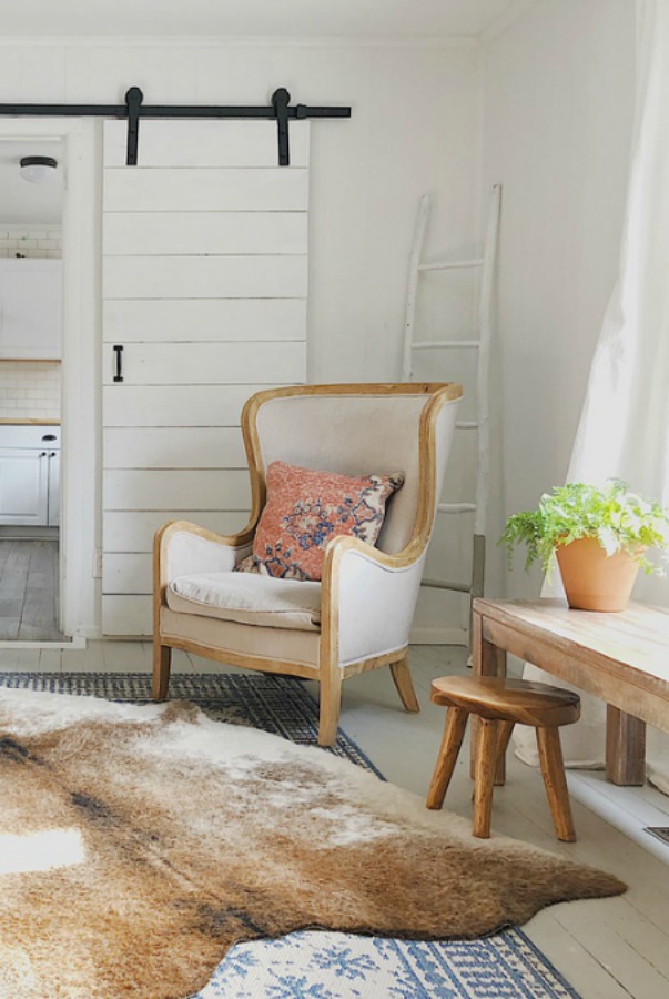 French style wing chair and cowhide rug in modern farmhouse.