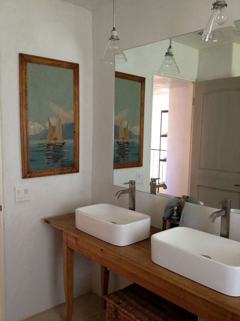 Bathroom with raised vessel sinks and repurposed antique vanity - by Giannetti Home. Pale and Lovely European Country White Interiors to Inspire with photo gallery. #frenchfarmhouse #interiordesign #frenchcountry