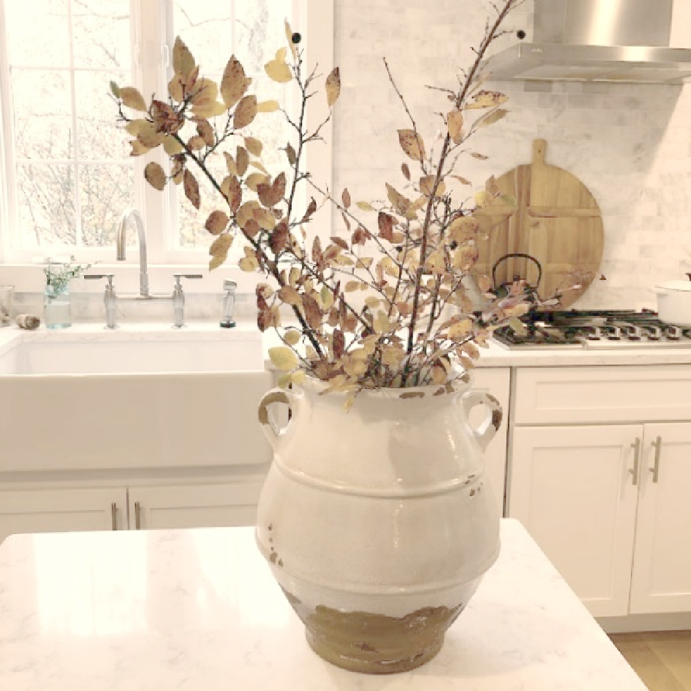 My serene white Modern French kitchen with terracotta urn and rustic branches - Hello Lovely Studio.