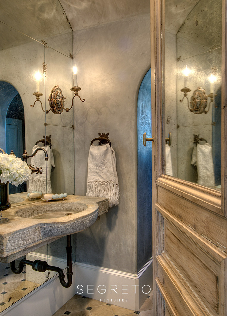 Gorgeous plaster walls (Segreto Finishes), stone sink, aged brass, and antique door in an Old World French country bath.