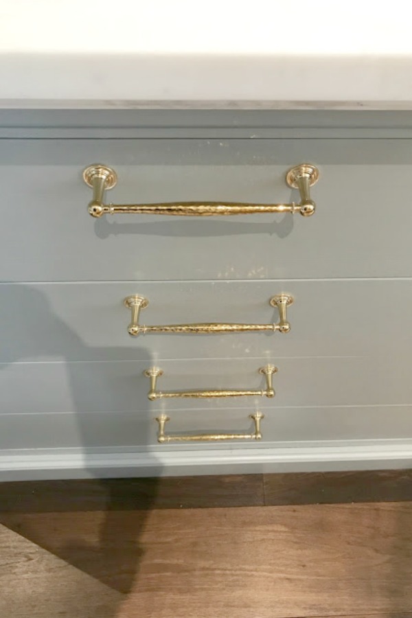 Brass drawer pulls on elegant kitchen cabinets painted Farrow & Ball Light Blue.