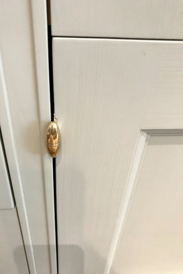 Detail of brass hardware on light blue handpainted kitchen cabinet.