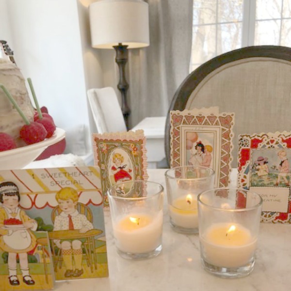 Vintage Valentine Decorations & Layer Cake. Come find simple inspiration for EASY, old fashioned, heart and love themed ideas like this simple layer cake with cherry lollipops and vintage cards on Hello Lovely Studio. #valentinesday #decorations #tablescape #layercake #vintagevalentinecards