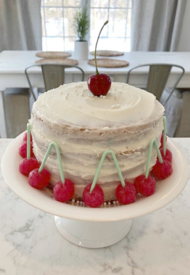 Vintage Valentine Decorations & Layer Cake. Come find simple inspiration for EASY, old fashioned, heart and love themed ideas like this simple layer cake with cherry lollipops and vintage cards on Hello Lovely Studio. #valentinesday #decorations #tablescape #layercake #vintagevalentinecards