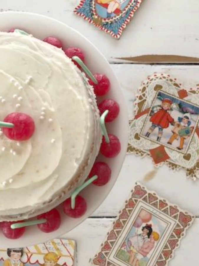 Vintage Valentine Decorations & Layer Cake. Come find simple inspiration for EASY, old fashioned, heart and love themed ideas like this simple layer cake with cherry lollipops and vintage cards on Hello Lovely Studio. #valentinesday #decorations #tablescape #layercake #vintagevalentinecards