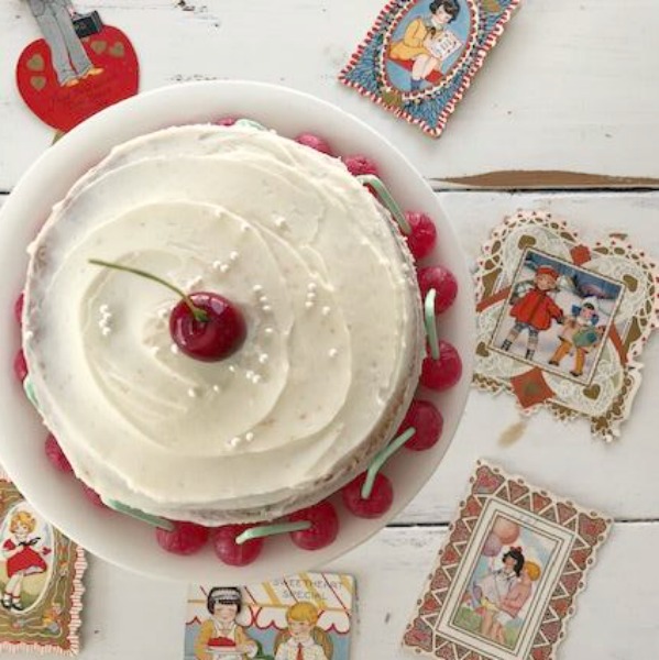 Vintage Valentine Decorations & Layer Cake. Come find simple inspiration for EASY, old fashioned, heart and love themed ideas like this simple layer cake with cherry lollipops and vintage cards on Hello Lovely Studio. #valentinesday #decorations #tablescape #layercake #vintagevalentinecards