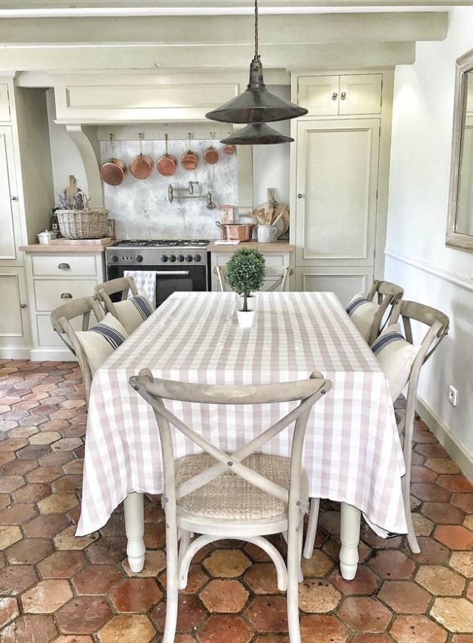 Terracotta hexagon tiles on kitchen floor in French farmhouse by Vivi et Margot. Pale and Lovely European Country White Interiors to Inspire with photo gallery.#frenchfarmhouse #interiordesign #frenchcountry