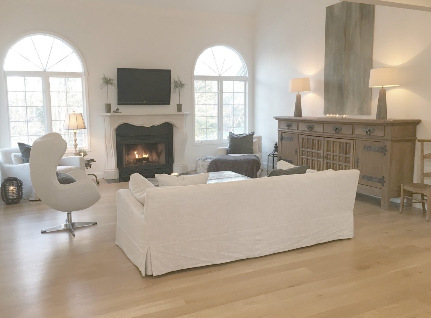 Belgian linen sofa, antique rustic sideboard from Belgium, and white oak flooring in my living room - Hello Lovely Studio.