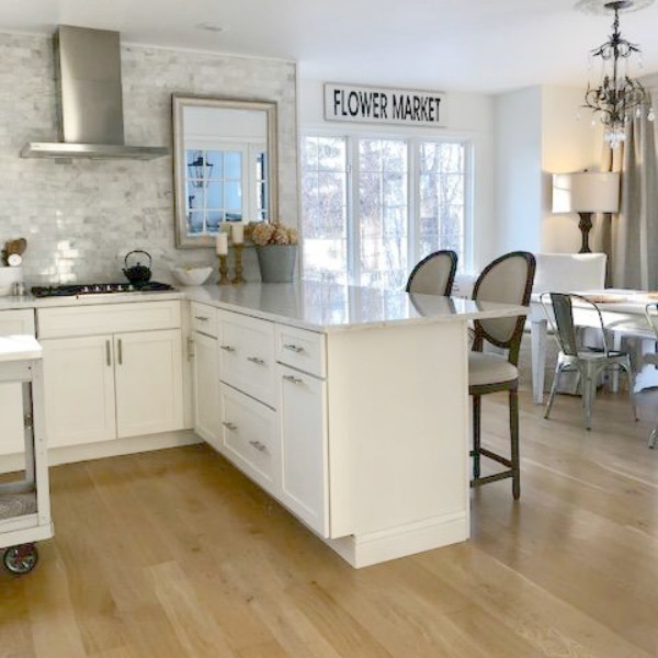 My classic white kitchen with industrial steel cart, marble backsplash, and Shaker cabinets. Hello Lovely Studio.