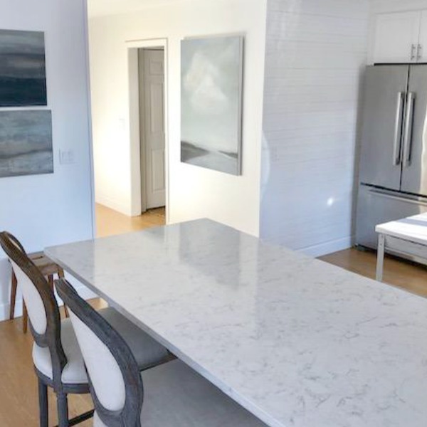 My classic white kitchen with industrial steel cart, marble backsplash, and Shaker cabinets. Hello Lovely Studio.