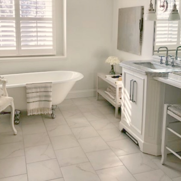 White bathroom with staggered porcelain tile floor and clawfoot tub - Hello Lovely Studio.