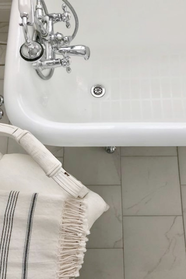 Detail of vintage clawfoot bathtub and porcelain tile floor - Hello Lovely Studio.