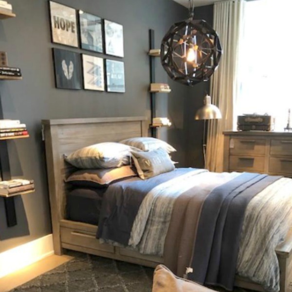 Masculine bedroom with dark grey wall and industrial farmhouse elements at RH Gallery Chicago. Photo: Hello Lovely Studio. Come tour photos of Restoration Hardware: Romantic French Decor Ideas on Hello Lovely Studio.