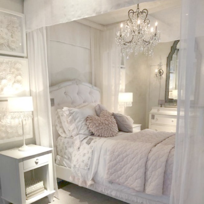 Gorgeous French romantic bedroom with canopy bed, crystal chandelier, pink bedding, and French country furniture. Come tour photos of Restoration Hardware: Romantic French Decor Ideas on Hello Lovely Studio.