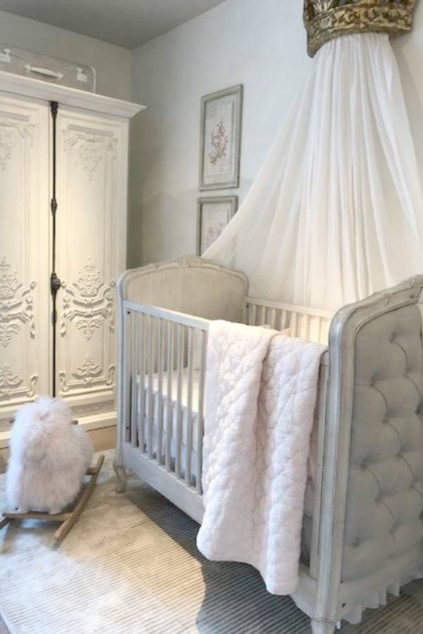 Beautiful French nursery with tufted linen upholstered crib, ornate armoire with cremone bolt, and sheepskin rocker - all by RH. Photo: Hello Lovely Studio. Come tour photos of Restoration Hardware: Romantic French Decor Ideas on Hello Lovely Studio.