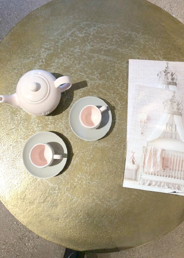 Pale pink tea set on a metallic round table at RH Gallery Chicago. Come tour photos of Restoration Hardware: Romantic French Decor Ideas on Hello Lovely Studio.