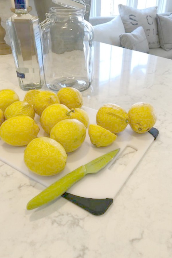 Lemons on a cutting board ready to be peeled for a limoncello recipe shared on Hello Lovely Studio. Kitchen Countertop material: Viatera Minuet quartz.