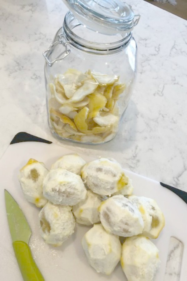 Peeled lemons on a cutting board for a recipe for limoncello - learn the easy instructions on Hello Lovely Studio.