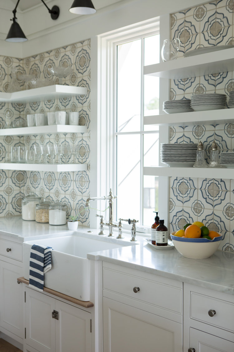 Gorgeous blue and white custom kitchen with floating shelves flanking farm sink - the handmade backsplash tile is a stunner - find the resources to get the look on Hello Lovely!