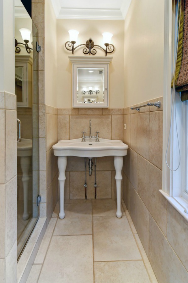 Farmhouse style console sink in a French country bathroom.