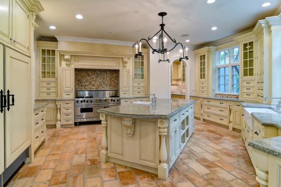 French country traditional style kitchen with rustic terracotta stone tile floor in a grand Hinsdale home.