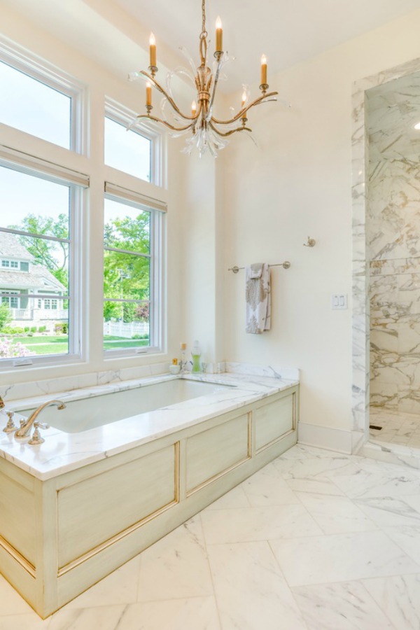 Painted wood bathtub apron in a luxurious white marble bathroom in a French country home. Come explore Realistic Country French Decor from Luxurious Ideas...certainly lovely indeed. Decorating ideas for French country style rooms as well as shopping resources.